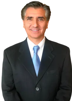 Middle-aged man in a suit representing Arlington Physical Therapy, smiling confidently in a neutral background.