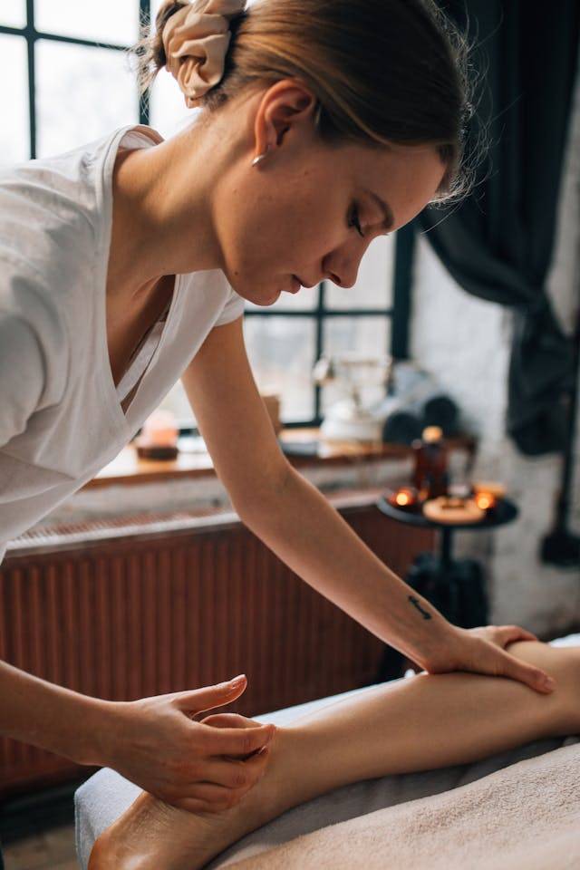 Massage therapist at Arlington Physical Therapy providing a calming massage with soft lighting and a cozy setting.